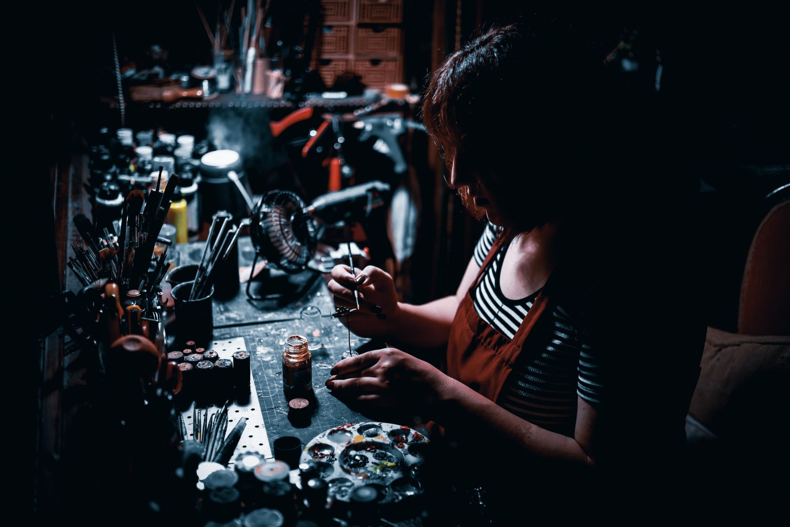 Pędzle, farby i ręczna praca przy warsztatowym stole — inspiracja działu modelarstwa